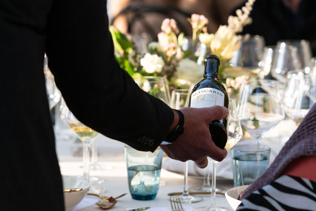 Mascarin_050424-108 Pouring a glass of Mascarin Family wine at a seated outdoor event